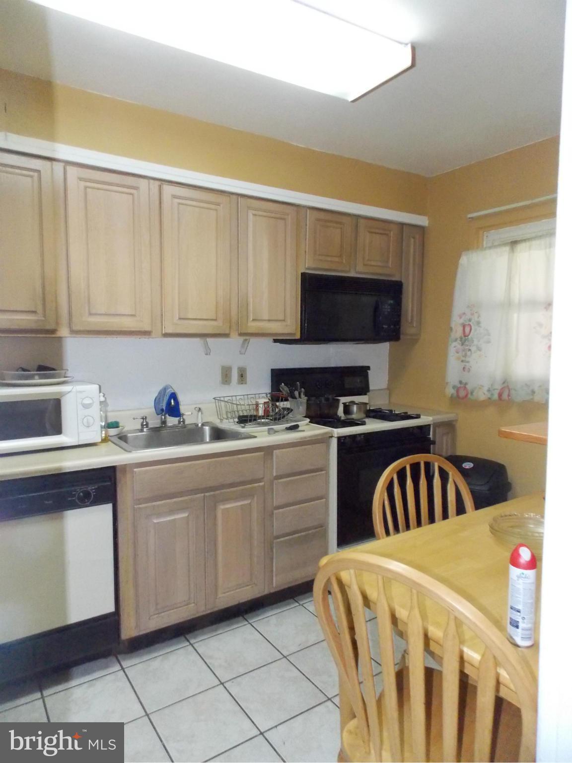 5021 Sunset Road Baltimore, MD 21215 - Photo 7 of 26 a kitchen with a sink a stove and a microwave