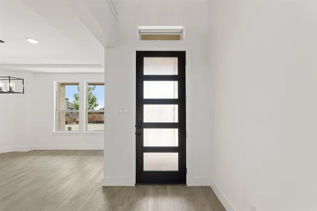 a view of empty room with wooden floor and ceiling fan