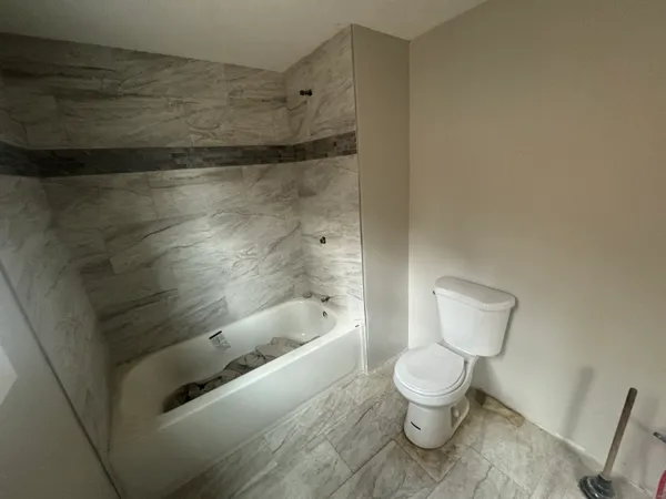 a bathroom with a toilet and a shower