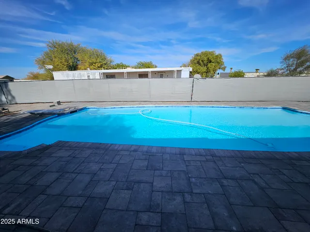 a view of a yard with wooden fence and a large tree