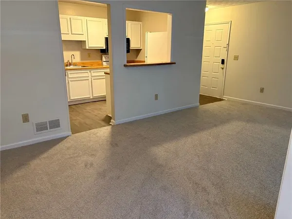a view of a kitchen with wooden floor and a window