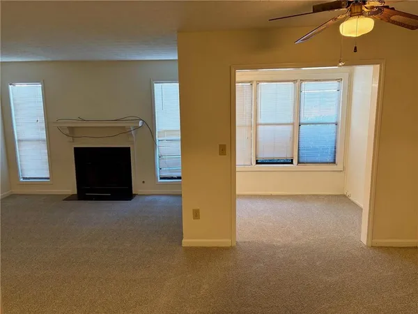 an empty room with windows and fireplace