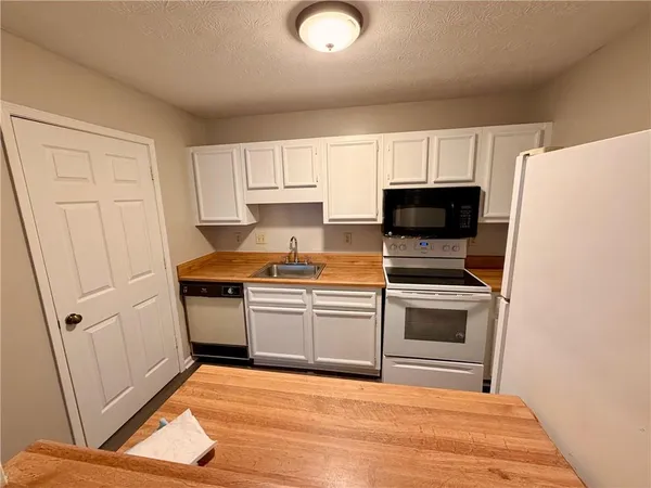 a kitchen with a sink a microwave and cabinets