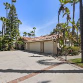 a front view of a house with a yard and potted plants