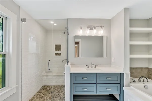 a bathroom with a sink shower and a mirror