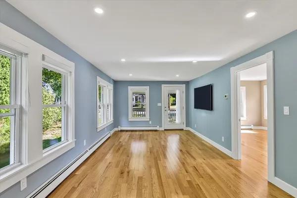 a view of empty room with wooden floor and fan