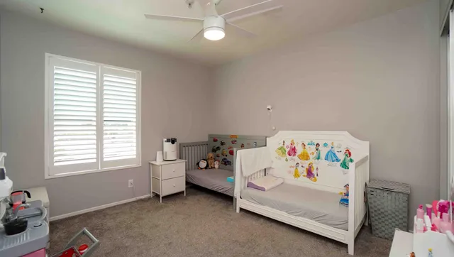 a white bed sitting in a bedroom next to a window