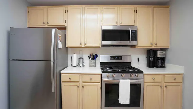 a kitchen with stainless steel appliances a refrigerator a stove a microwave and cabinets