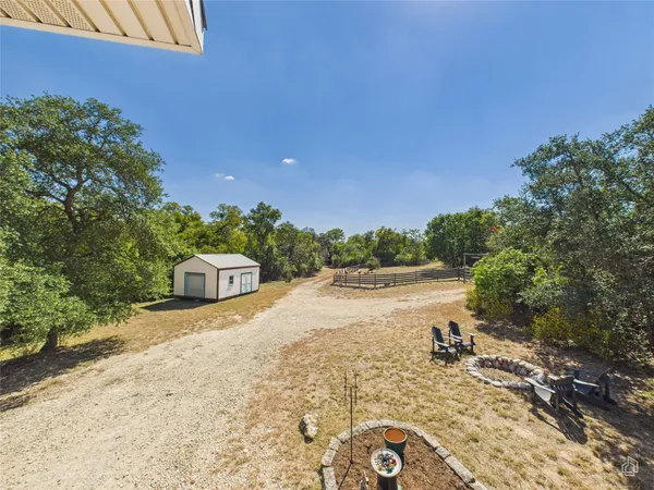 a backyard of a house with lots of green space and wooden fence