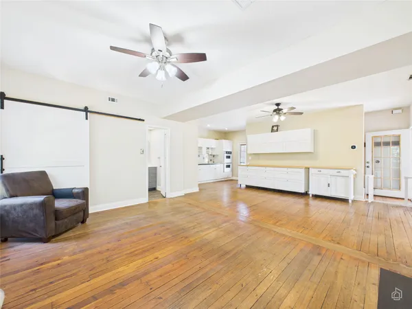 a view of a livingroom with furniture a ceiling fan and wooden floor