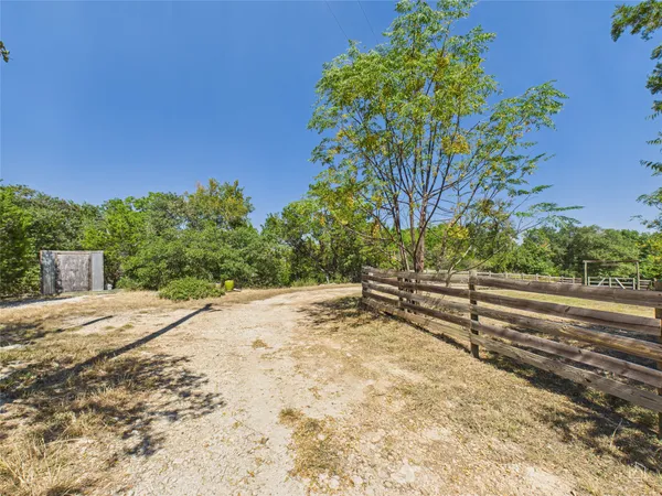 a view of a yard with wooden fence