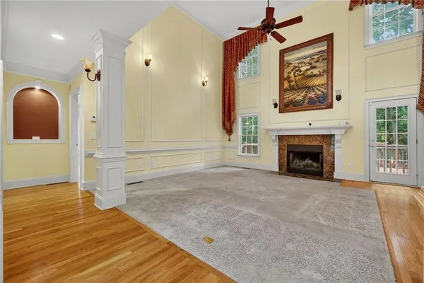 a view of an empty room with wooden floor and a fireplace