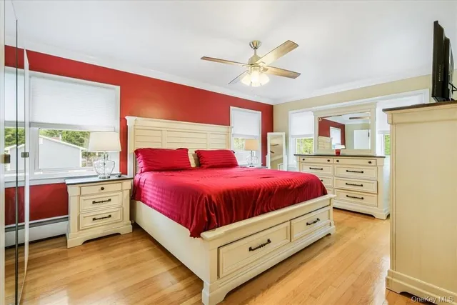 a spacious bedroom with a bed and a flat tv screen