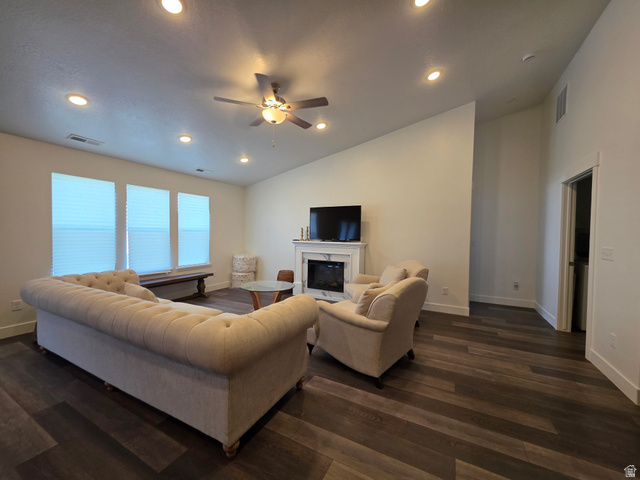 1237 West 3440 South Logan, UT 84321 - Photo 15 of 29 Spacious living area featuring a curved sectional sofa arrangement, wood-finish flooring throughout, and a fireplace with built-in entertainment center