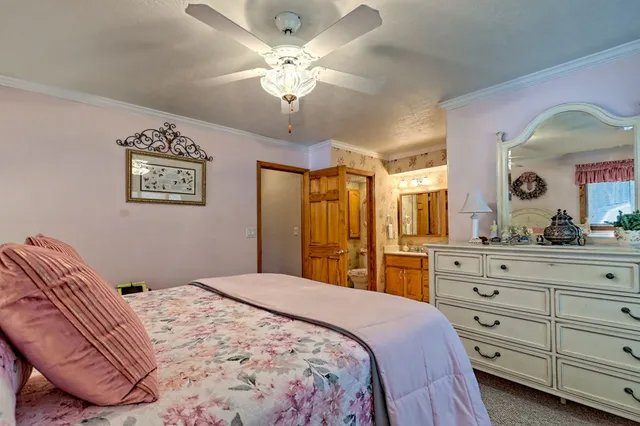 a bedroom with a bed and a flat tv screen on the dresser