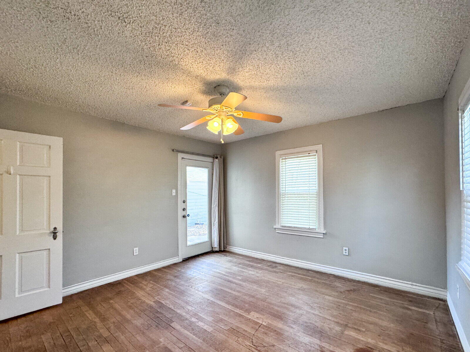 2622 25th Street Lubbock, TX 79410 - Photo 12 of 12 an empty room with wooden floor fan and windows