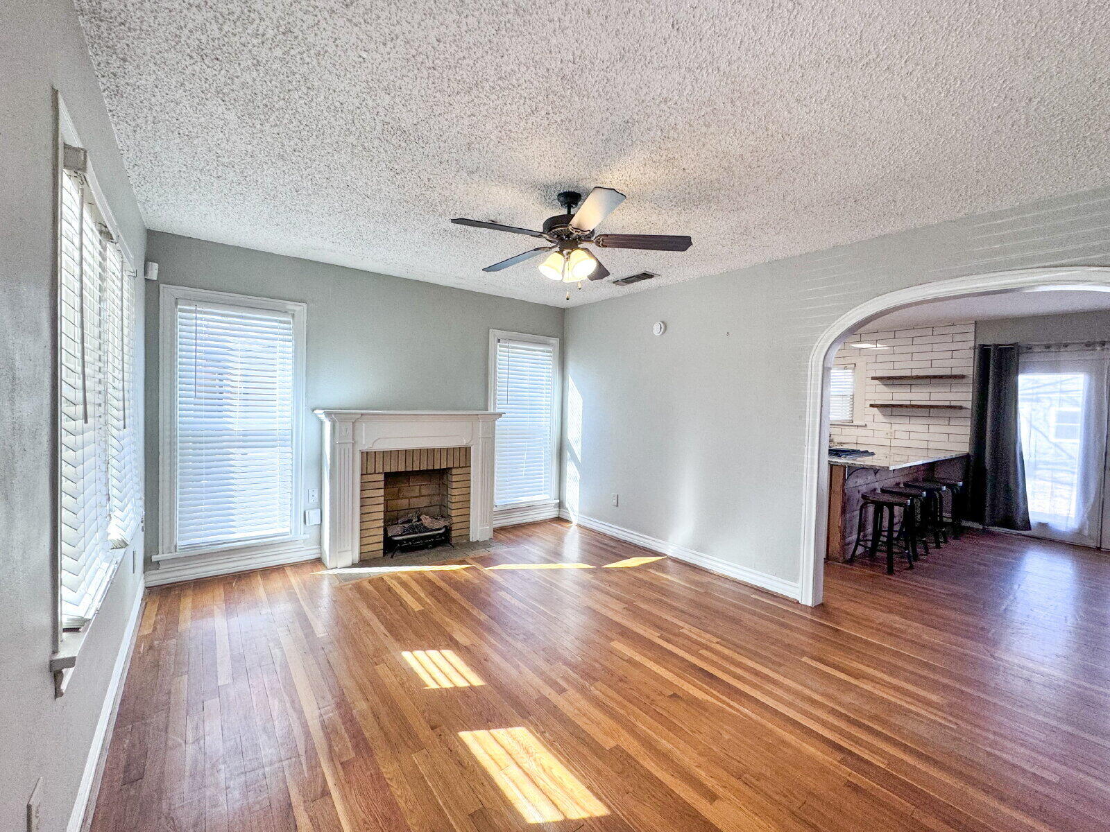 2622 25th Street Lubbock, TX 79410 - Photo 2 of 12 wooden floor fireplace and windows in an empty room