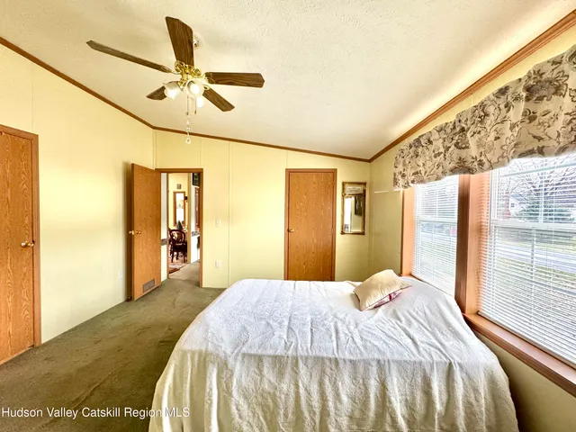 a bedroom with a bed and dresser with wooden floor
