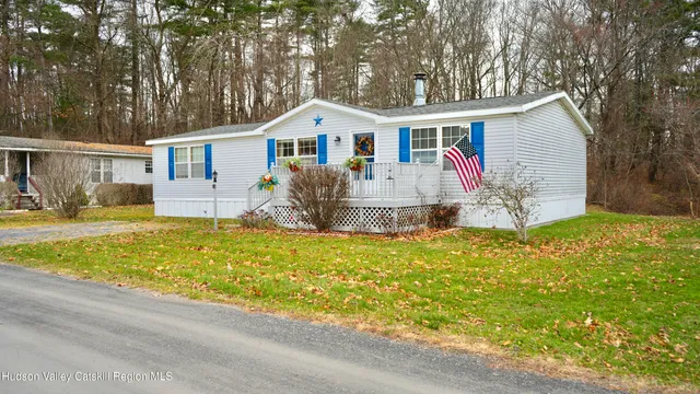a front view of house with yard and trees around