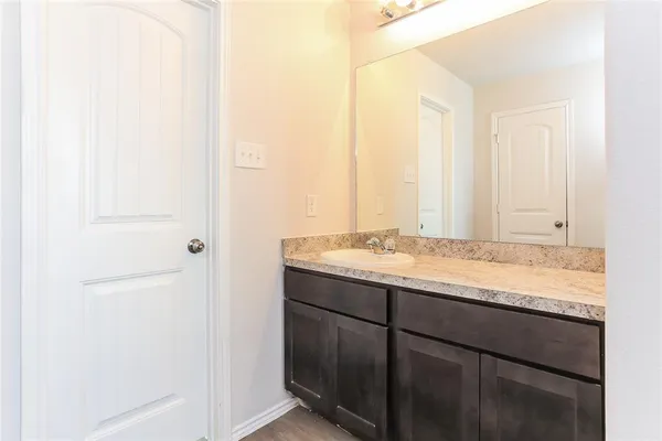 a bathroom with a granite countertop sink and a mirror