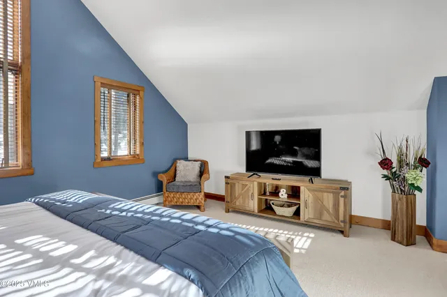 a view of a white house with a small yard and wooden fence