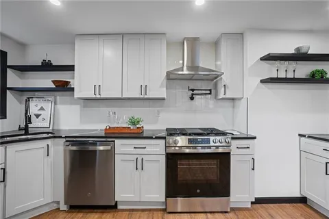 a kitchen with stainless steel appliances granite countertop a stove a sink and a microwave