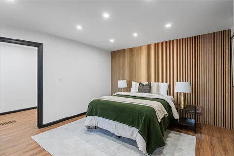 a bedroom with a bed and a wooden floor