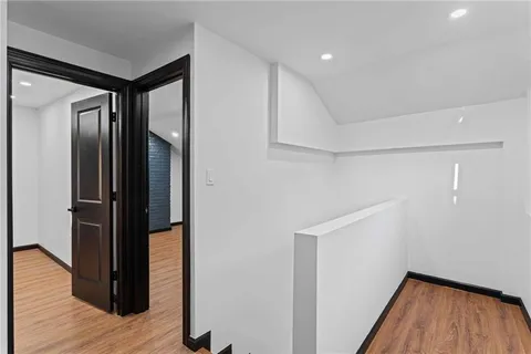 a view of hallway with walk in closet and wooden floor