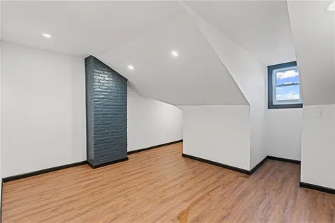 a view of an empty room with wooden floor and closet