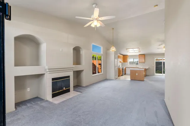 a view of a livingroom with a ceiling fan and kitchen view