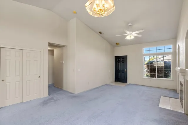 a view of an empty room with a window and fireplace