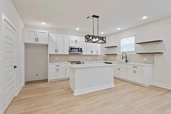 a kitchen with a refrigerator a sink and cabinets