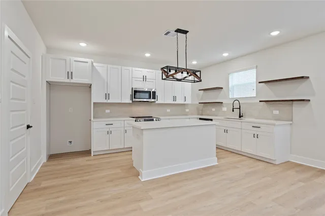 a kitchen with a refrigerator a sink and cabinets