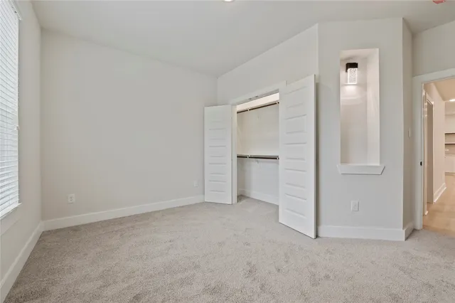 an empty room with closet and windows