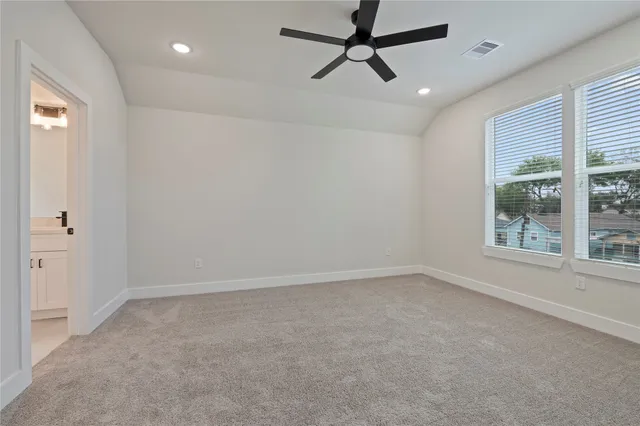 an empty room with a window and a fan