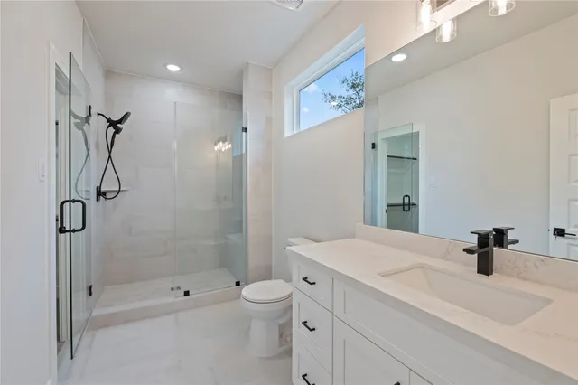 a bathroom with a sink a toilet and shower