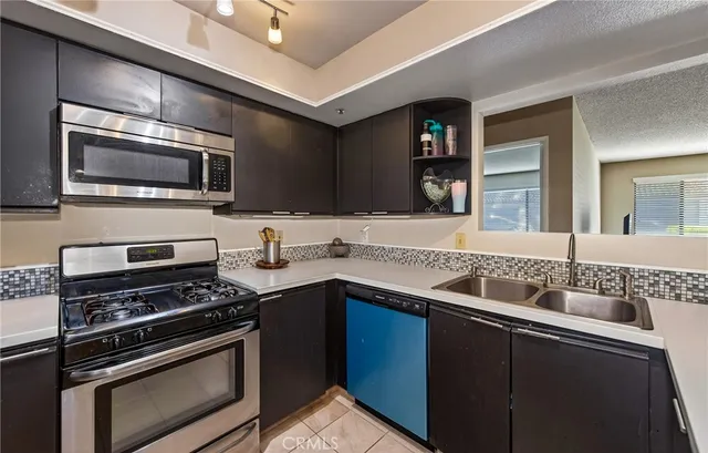 a kitchen with a sink and steel appliances