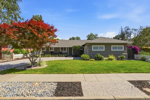 a front view of a house with a garden and yard