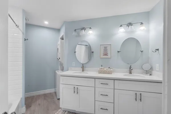 a bathroom with double vanity sink and a mirror