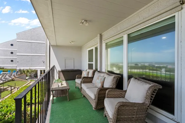 a balcony with couple of chairs and a couch
