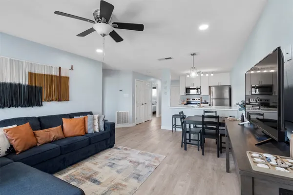 a living room with furniture kitchen view and a flat screen tv