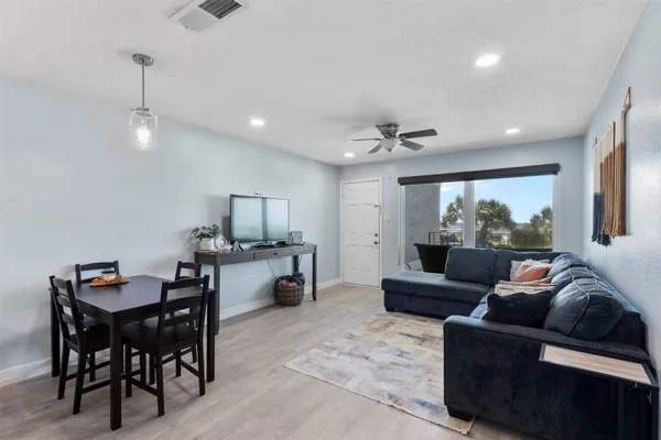 a living room with furniture and a wooden floor