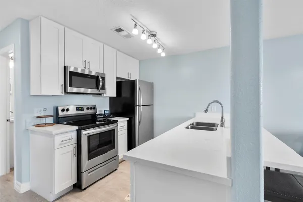 a kitchen with kitchen island a stove a sink and a refrigerator