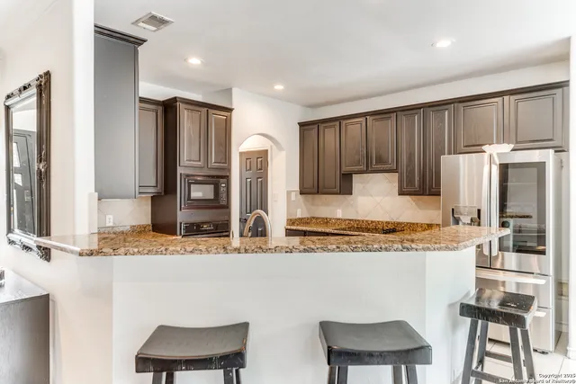 a kitchen with granite countertop a sink stove and cabinets