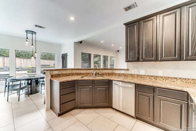 a kitchen with stainless steel appliances granite countertop a refrigerator and cabinets