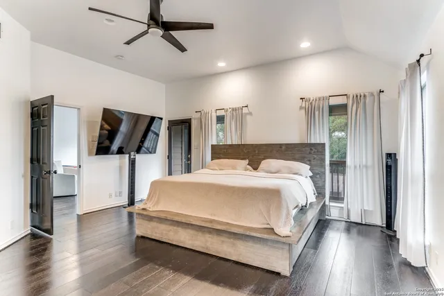 a spacious bedroom with a bed and wooden floor