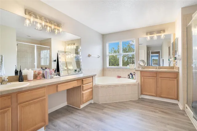 a spacious bathroom with a double vanity sink a large mirror and a bathtub