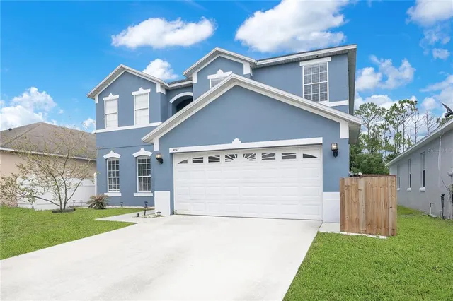 a view of a white house with a big yard and large tree