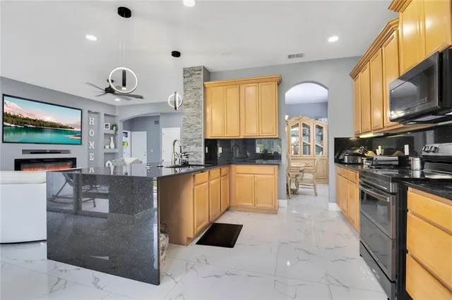 a large kitchen with stainless steel appliances granite countertop a stove and a sink