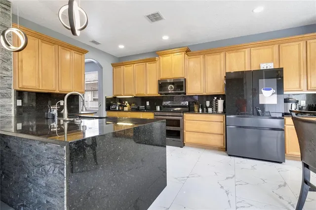 a kitchen with stainless steel appliances granite countertop a stove a sink and a microwave
